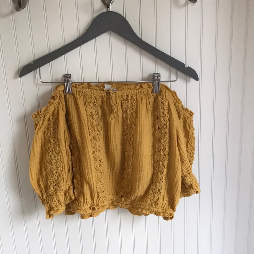 A yellow ruffled cropped shirt